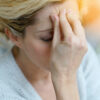 Portrait of middle-aged blond woman having a migraine