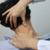 Closeup of Doctor examines or treatment the man with shoulder pain or neck pain on white background,Healthcare and Medicine concept