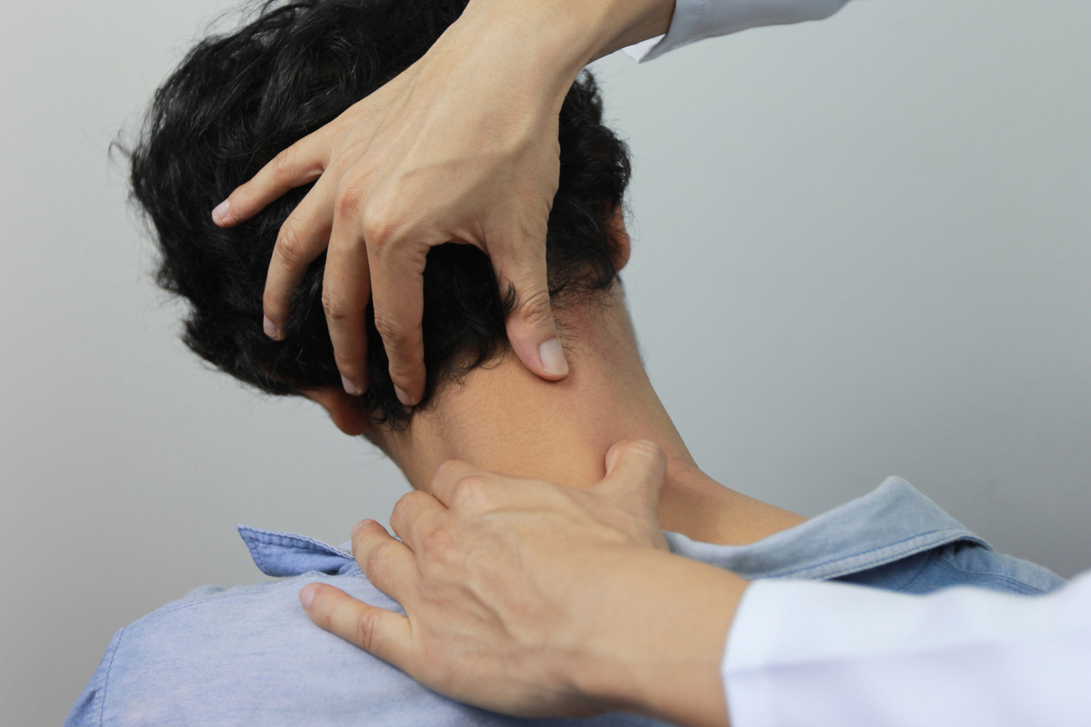 Closeup of Doctor examines or treatment the man with shoulder pain or neck pain on white background,Healthcare and Medicine concept