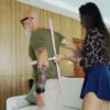 A wife is performing a home physiotherapy program on her husband to correct his posture