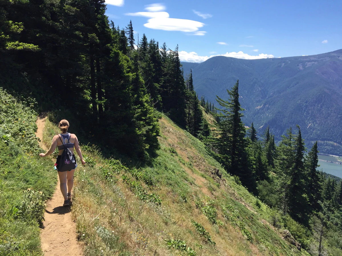 Summer Hikes in Oregon. Girl hiking in mountains or forest with summer cloths. Hobbies that are outdoors. Women enjoying a hike on her own. Hike with many trees and great view. Summer day adventures.