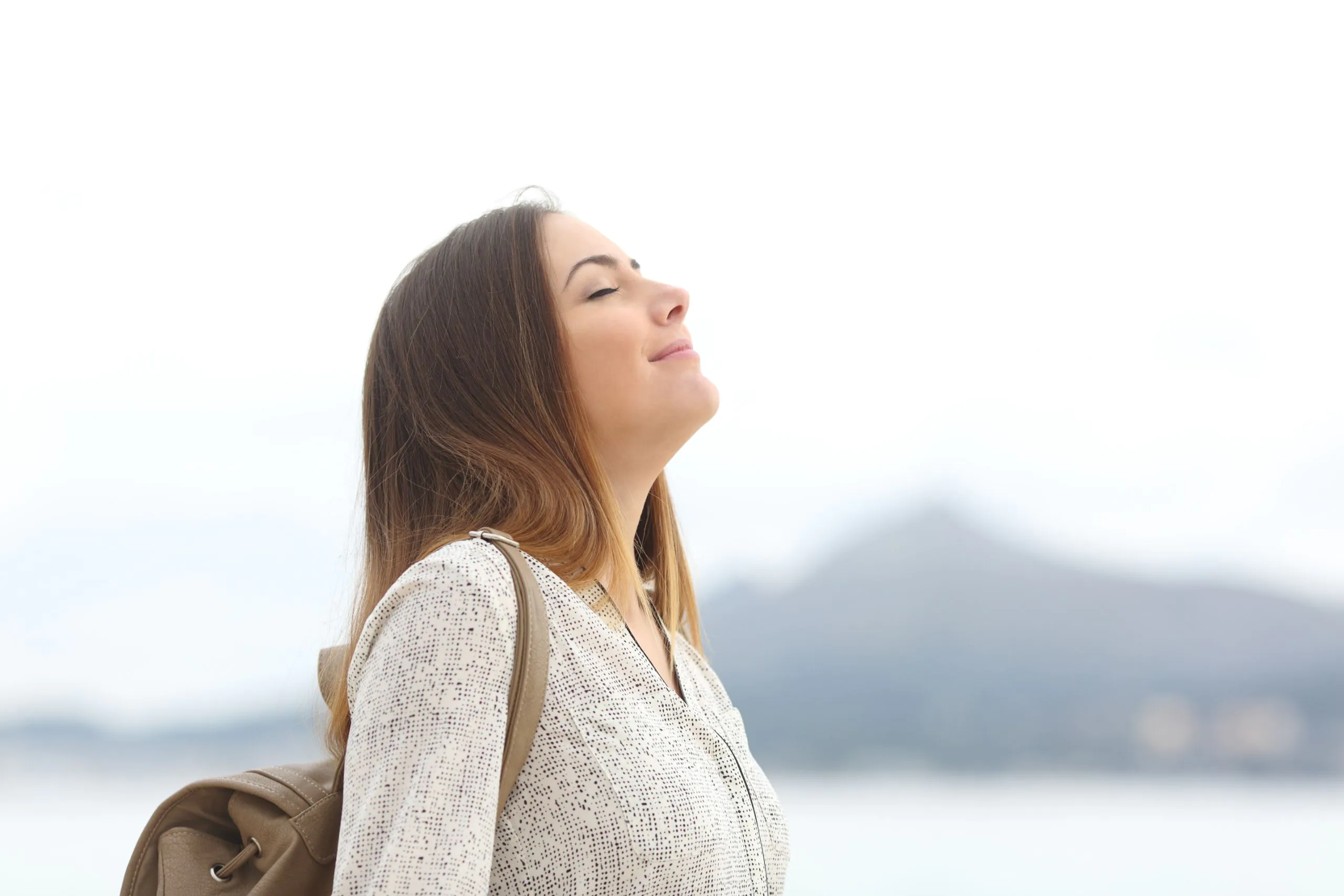 Happy woman on the beach breathing fresh air