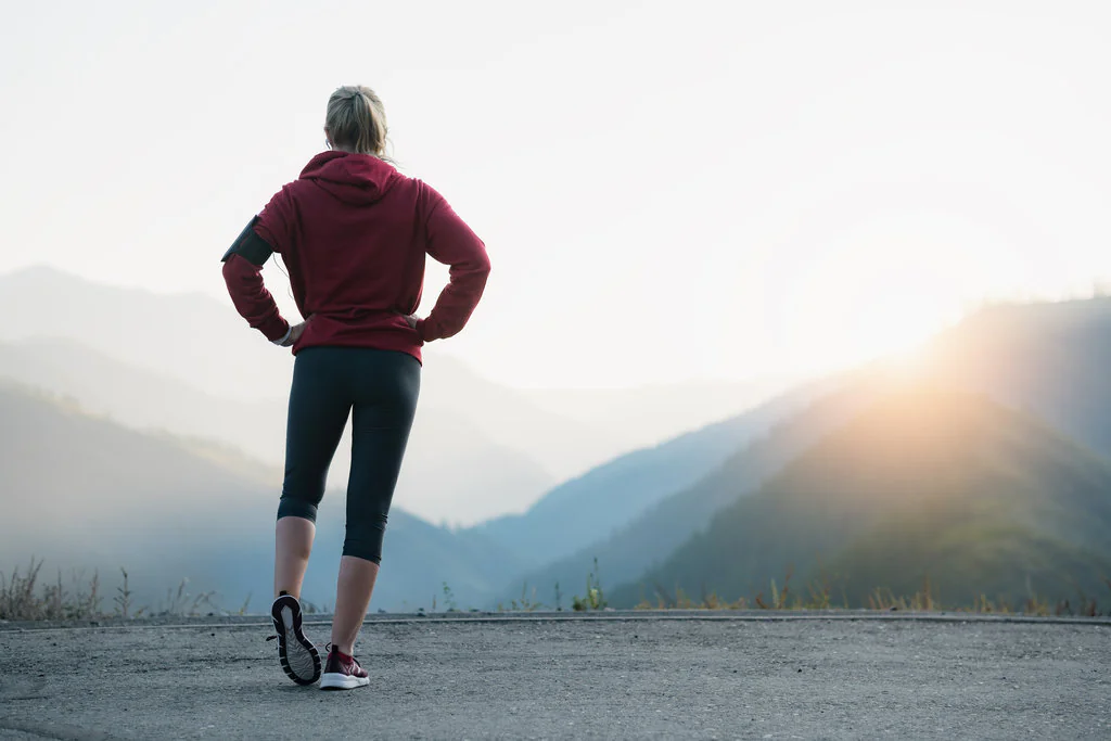 Running stretching. Athlete at the top of the mountain.