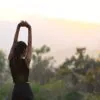 Woman stretching outdoors at sunset as part of a holistic summer wellness routine in Bend Oregon