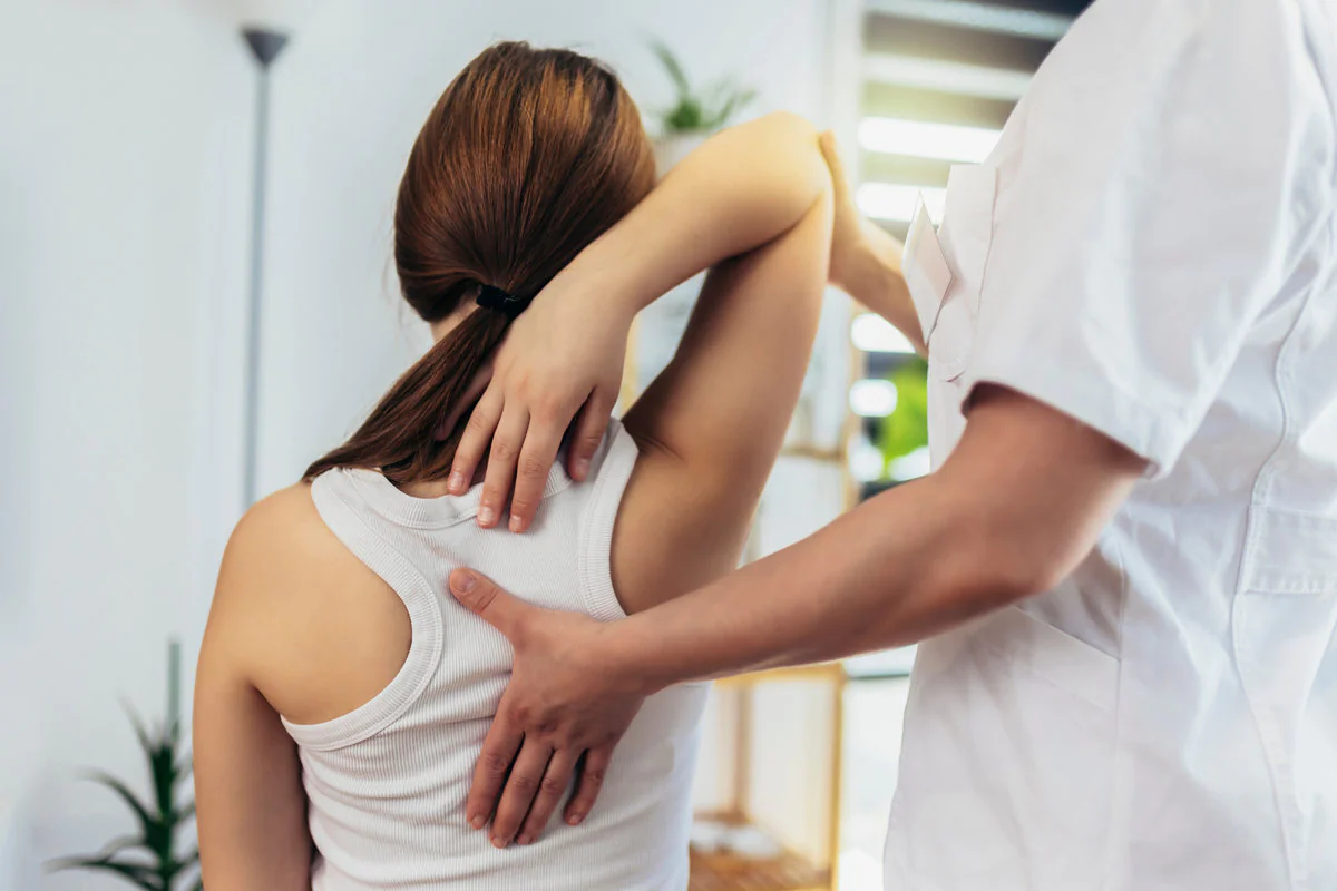 Teen Girl having chiropractic back adjustment. Osteopathy, Physiotherapy, Kinesiology. Bad posture correction