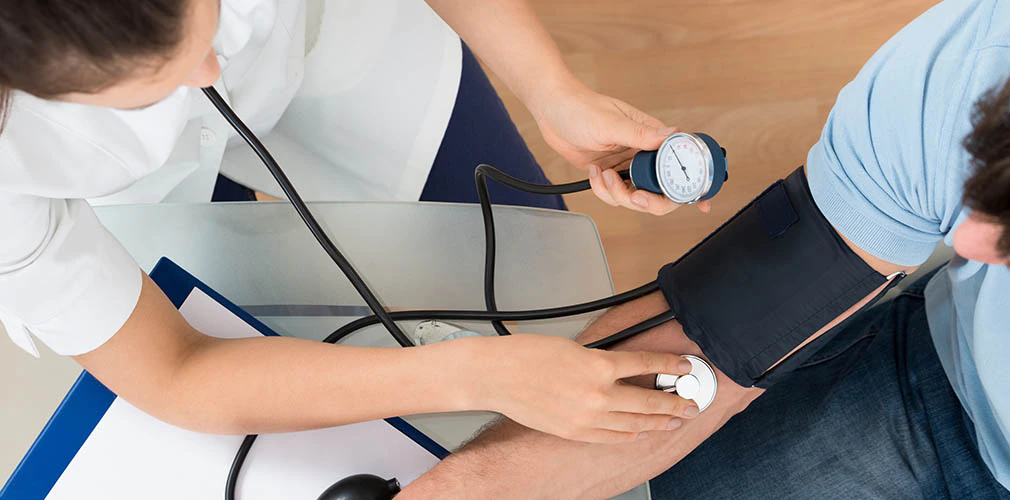 The doctor measures blood pressure.