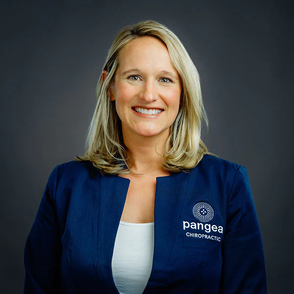 Dr. Ashley Campbell, COO and Clinic Director at Pangea Chiropractic, smiling in professional attire