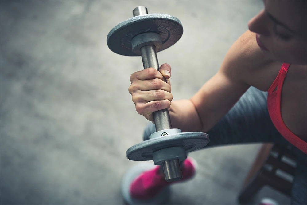 girl holding dumbbells